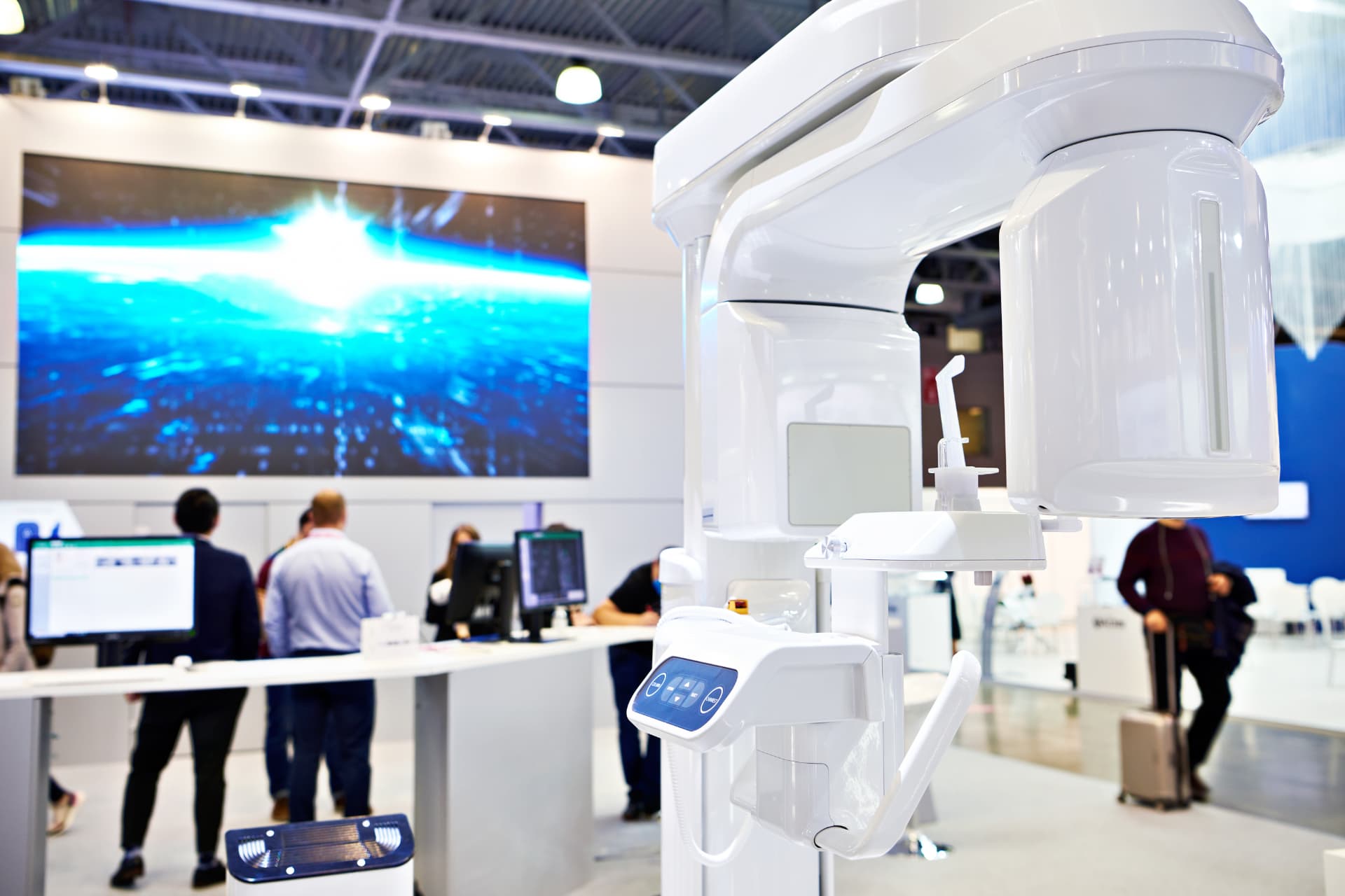 Cone-beam CT scanner displayed at a dental equipment show, the three-dimensional imaging technology implant practices evaluate when deciding whether owning a CBCT scanner beats referring