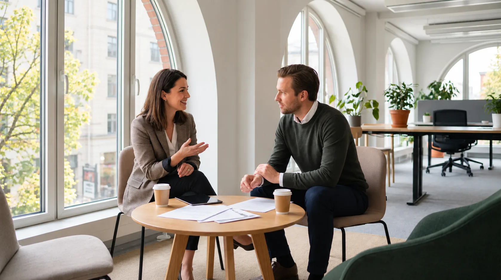 Treatment coordinator interview at a round table in a bright office, a candidate explaining a plan to an attentive interviewer over coffee and printed notes, the conversation that tests whether a manner survives a fee conversation